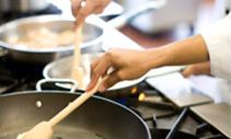 Chefs working with cheese in a kitchen.
